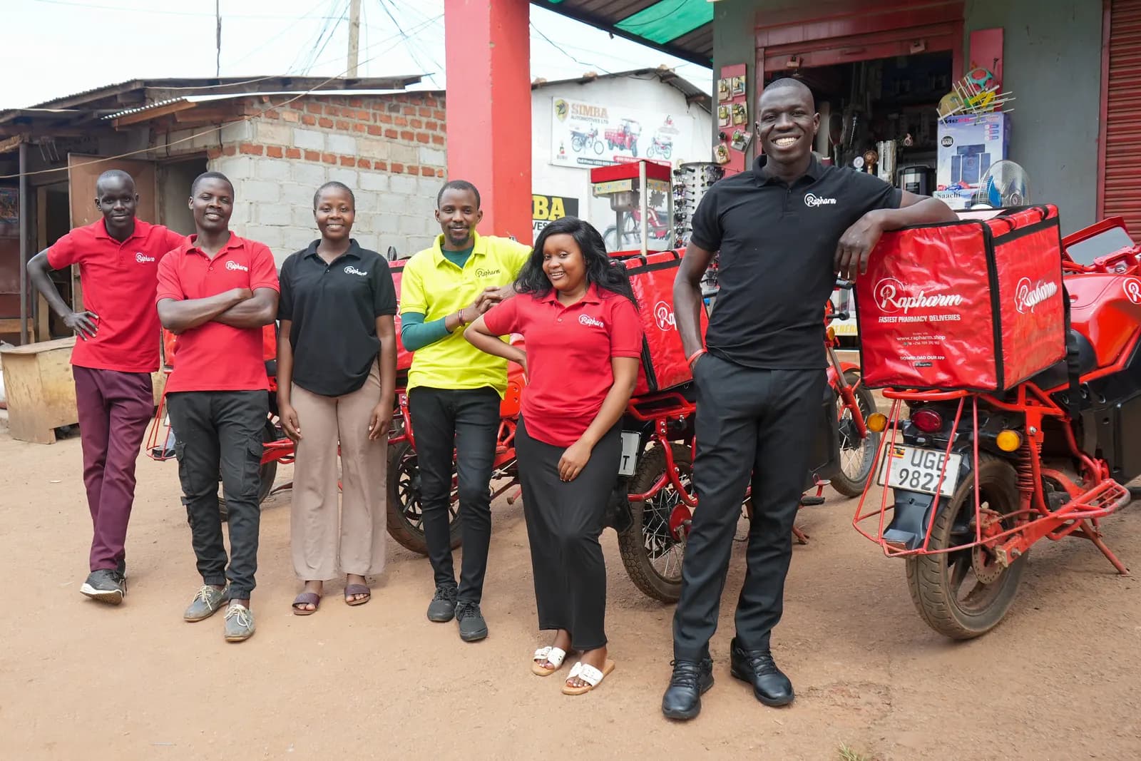 Rapharm pharmacists and delivery riders outside a Kampala pharmacy